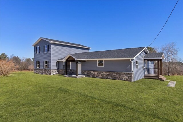 view of front facade with stone siding and a front lawn