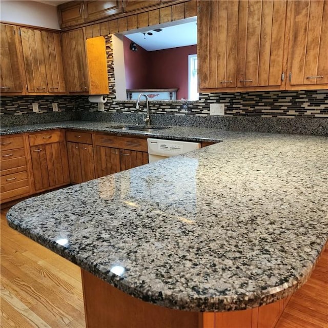 919 W Broad St, Horseheads, NY 14845 - kitchen featuring brown cabinetry, a sink, and decorative backsplash