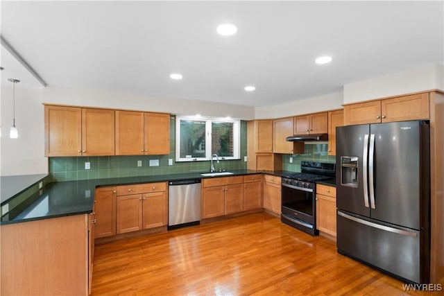 67 Nottingham Ter, Buffalo, NY 14216 - kitchen with stainless steel appliances, a sink, under cabinet range hood, dark countertops, and backsplash