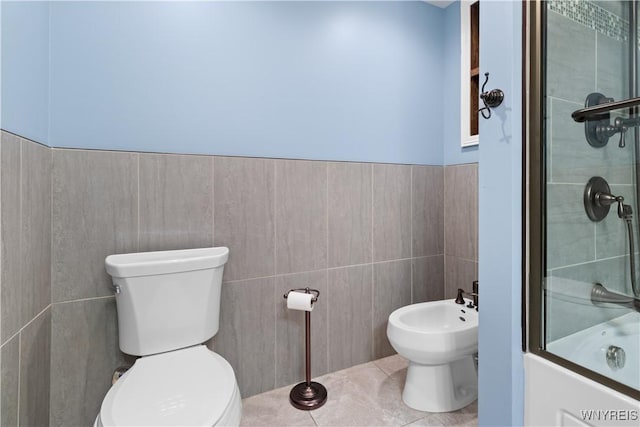 67 Nottingham Ter, Buffalo, NY 14216 - bathroom with tile walls, toilet, a bidet, tile patterned flooring, and a wainscoted wall