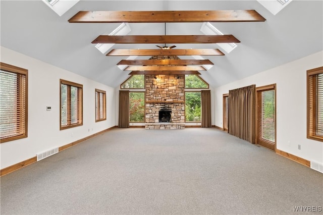 67 Nottingham Ter, Buffalo, NY 14216 - unfurnished living room with beamed ceiling, carpet floors, a skylight, baseboards, and a stone fireplace