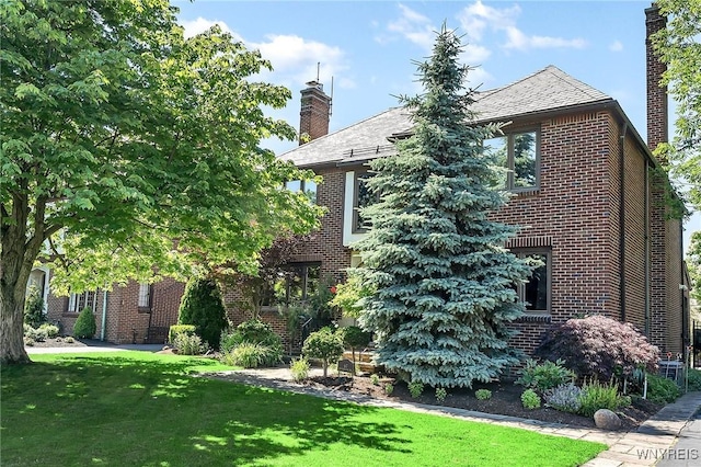 67 Nottingham Ter, Buffalo, NY 14216 - view of front of house with a chimney, brick siding, and a front lawn