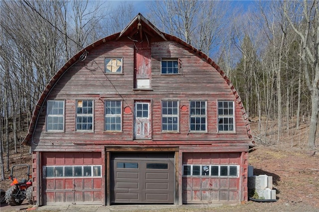 exterior space with a gambrel roof and a garage