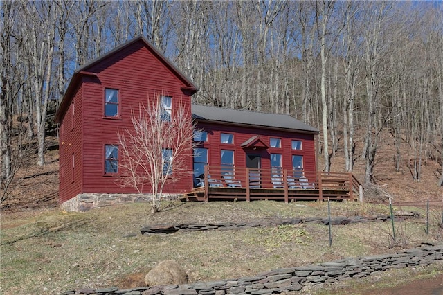 view of front facade with a view of trees and a wooden deck