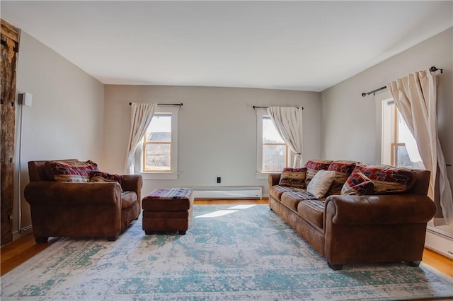 living room with wood finished floors, baseboard heating, and a wealth of natural light