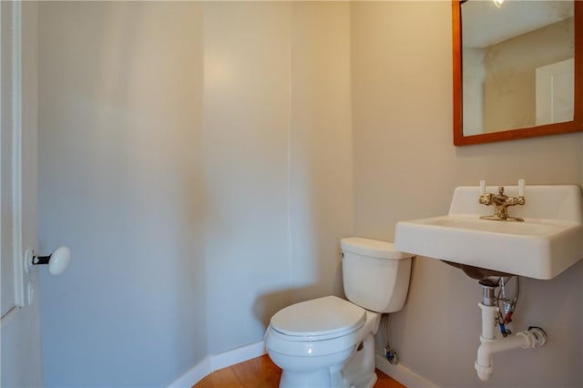 half bath featuring toilet and baseboards