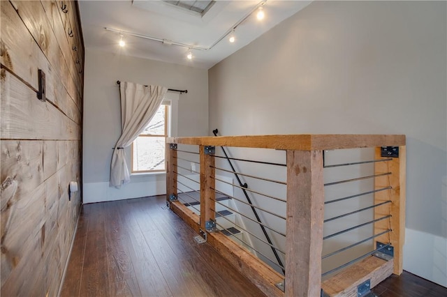 staircase featuring wood finished floors and track lighting