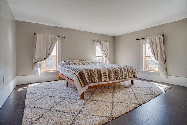 bedroom featuring wood finished floors and multiple windows