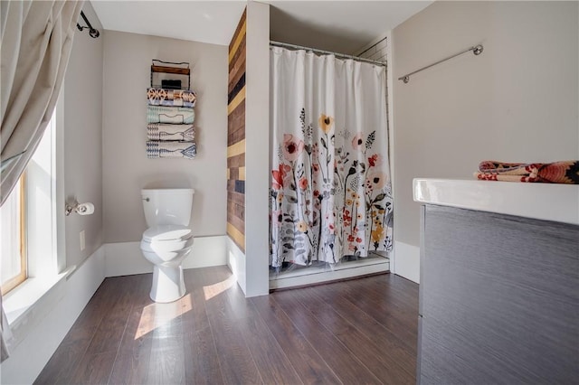 full bathroom with toilet, wood finished floors, and curtained shower