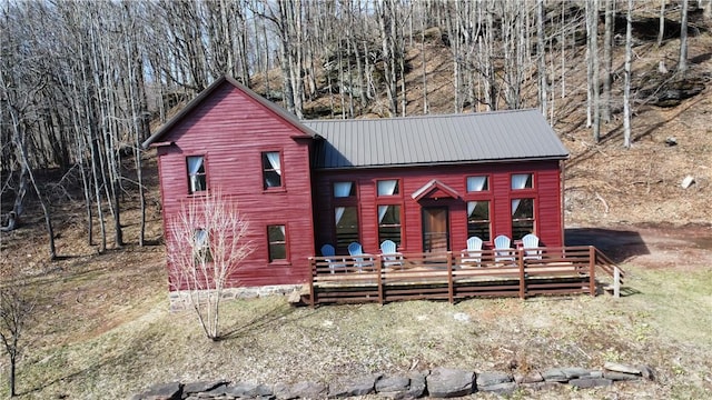 rear view of house featuring metal roof and a wooden deck