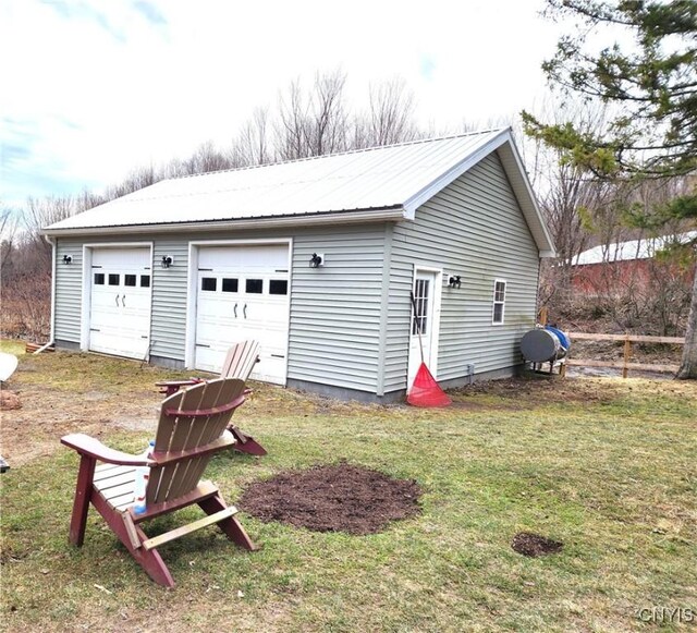detached garage featuring heating fuel and fence