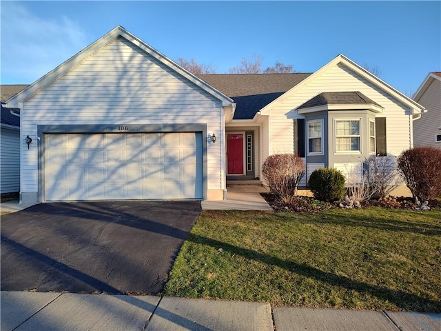 ranch-style home with a front lawn, a garage, and driveway