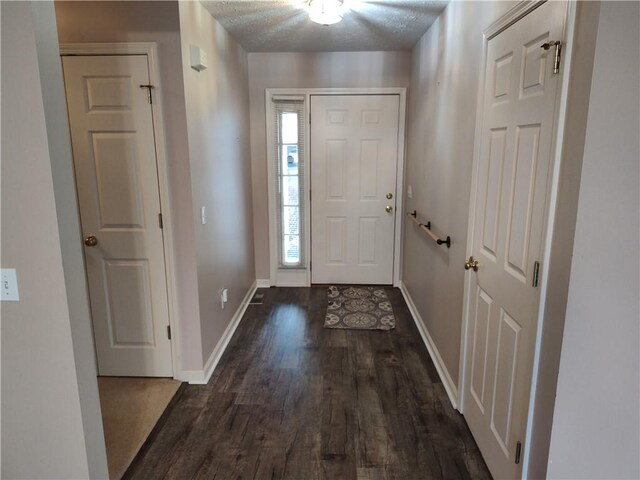 entrance foyer featuring dark wood finished floors, baseboards, and a textured ceiling