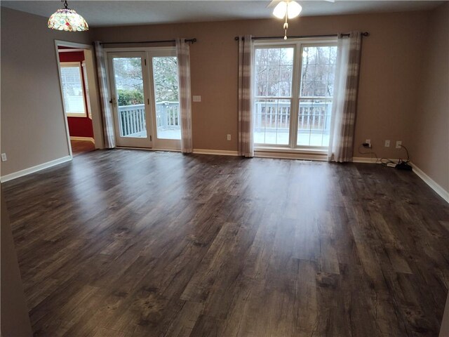 unfurnished room featuring dark wood-type flooring, baseboards, and ceiling fan