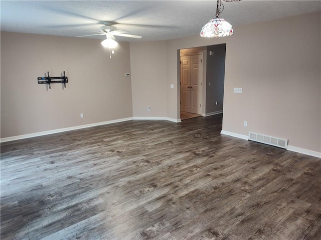 spare room featuring visible vents, wood finished floors, baseboards, and ceiling fan