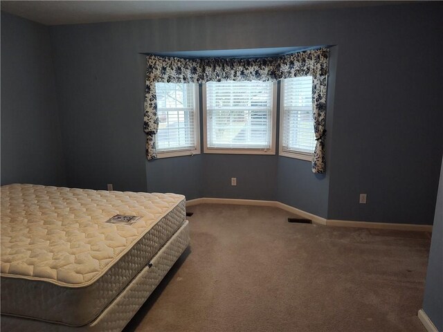 bedroom with carpet, visible vents, and baseboards