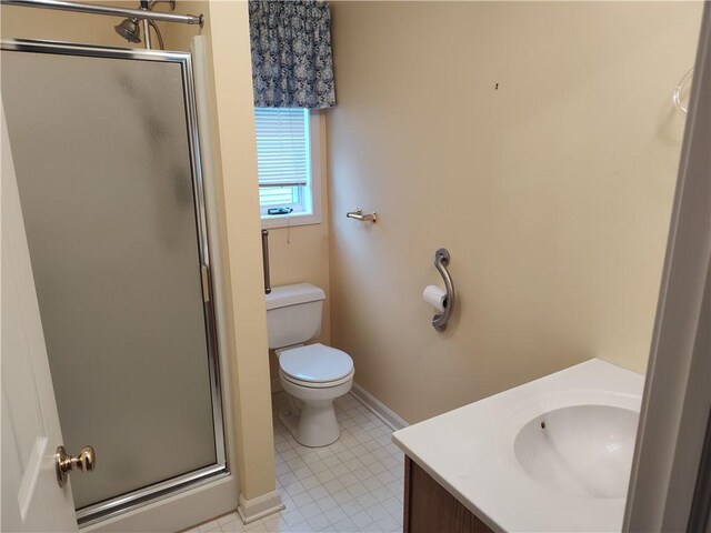 bathroom with baseboards, vanity, toilet, and a shower stall