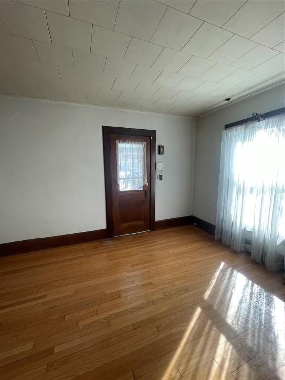 foyer featuring plenty of natural light, light wood-style floors, and baseboards