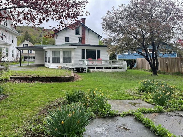 rear view of property with a chimney and a deck