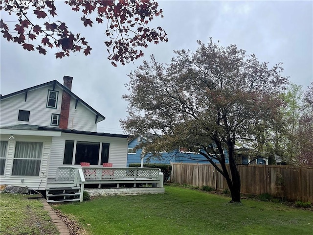 back of house with a wooden deck and a chimney