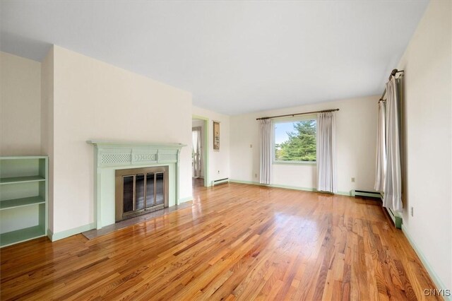 unfurnished living room with baseboards, a fireplace with flush hearth, light wood-style floors, and a baseboard heating unit