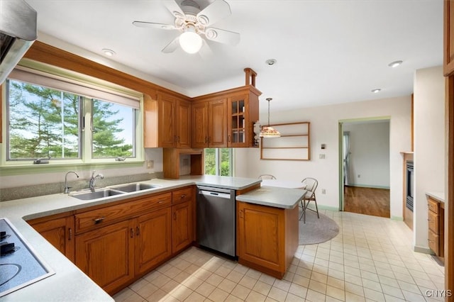 kitchen with dishwasher, a peninsula, light countertops, and a sink