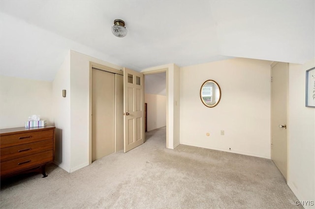 interior space with vaulted ceiling, light colored carpet, and a closet