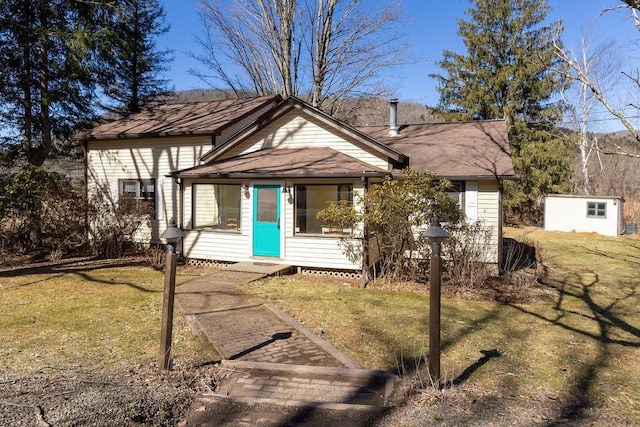 view of front of home featuring an outdoor structure and a front yard