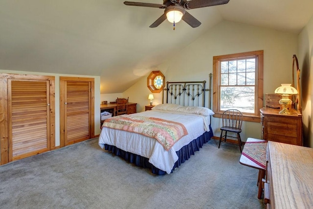 bedroom with two closets, a ceiling fan, carpet, and lofted ceiling