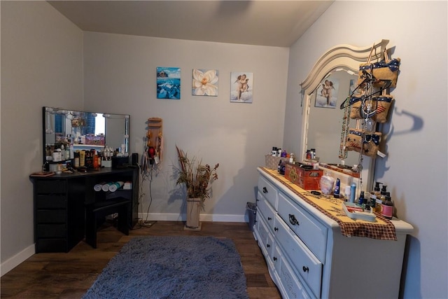 interior space with a dry bar, baseboards, and dark wood-style flooring