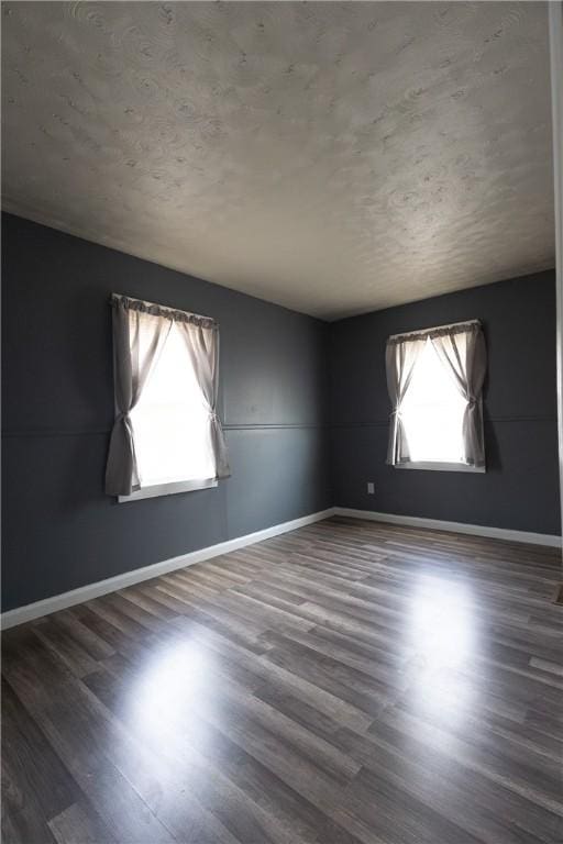 empty room with baseboards and wood finished floors