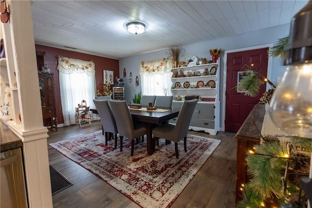 dining room with hardwood / wood-style floors, wooden ceiling, and visible vents