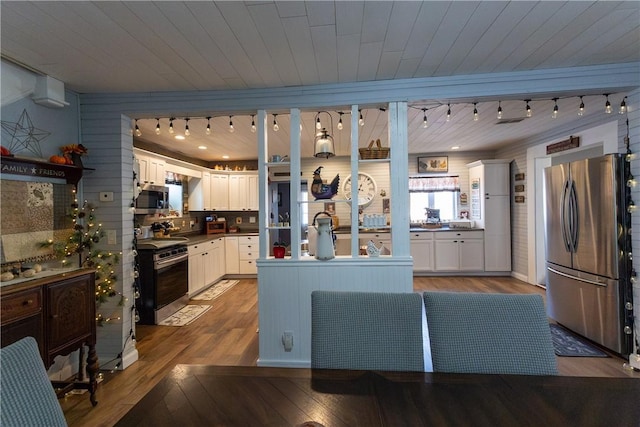 kitchen featuring light wood-type flooring, appliances with stainless steel finishes, white cabinets, and wooden ceiling