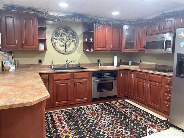 kitchen featuring light countertops, open shelves, recessed lighting, a sink, and appliances with stainless steel finishes