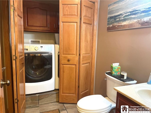 bathroom with toilet, washer / clothes dryer, and vanity