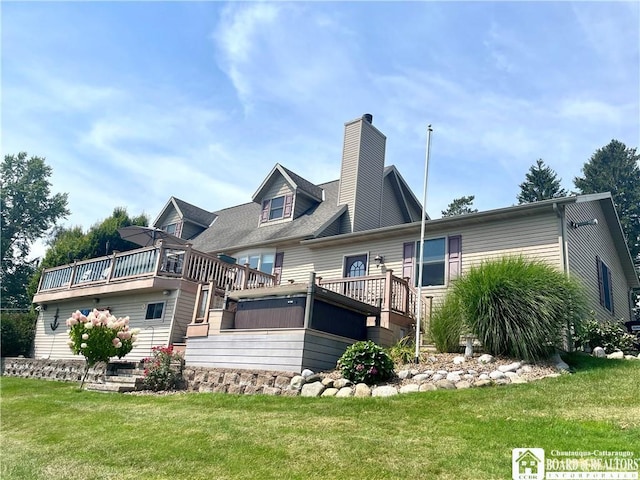 rear view of property with a chimney, a deck, and a yard