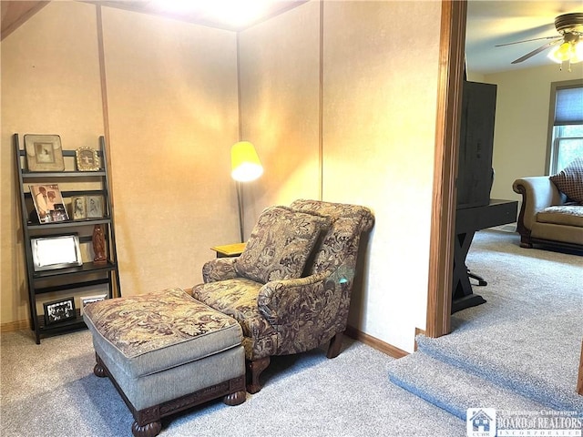 sitting room featuring baseboards, carpet, and a ceiling fan