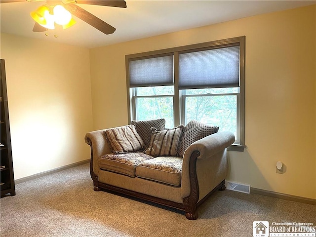 living room featuring a ceiling fan, carpet floors, baseboards, and visible vents