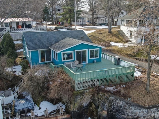 back of property featuring a deck, fence, a residential view, and a shingled roof