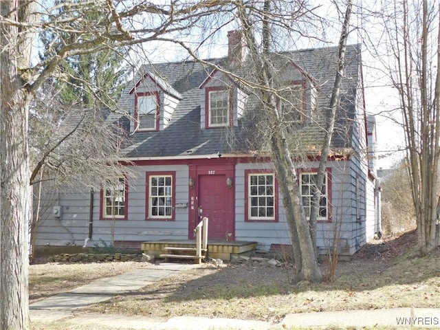 cape cod home with roof with shingles and a chimney
