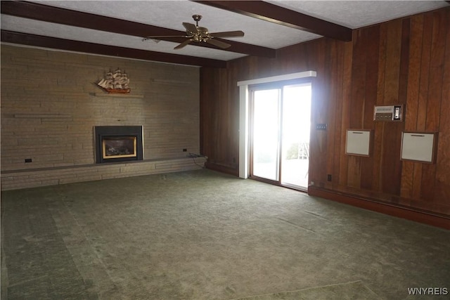 480 Lakeview Ave, Orchard Park, NY 14127 - unfurnished living room with beamed ceiling, a fireplace, carpet floors, a ceiling fan, and wood walls