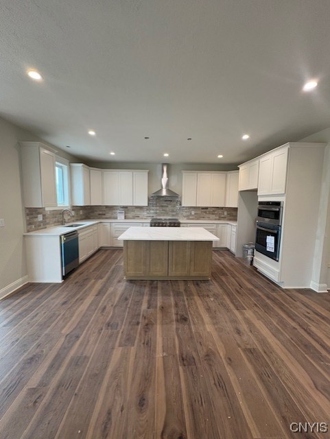 3515 Tall Tree Ln, Lysander, NY 13027 - kitchen featuring a sink, dark wood finished floors, tasteful backsplash, and wall chimney exhaust hood