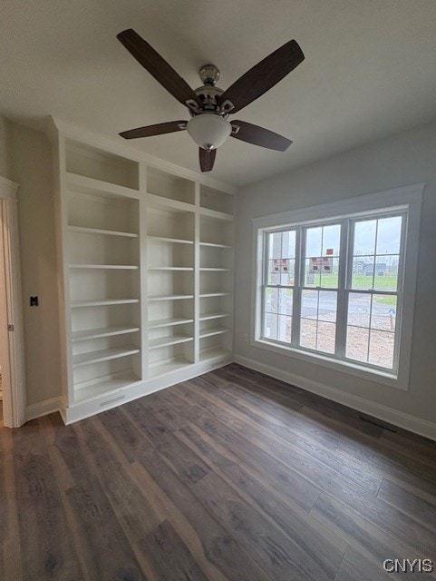 3515 Tall Tree Ln, Lysander, NY 13027 - empty room with dark wood-style flooring, baseboards, ceiling fan, and built in features