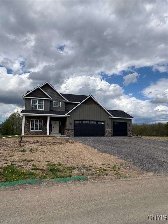 3515 Tall Tree Ln, Lysander, NY 13027 - craftsman inspired home with covered porch, a garage, stone siding, and driveway