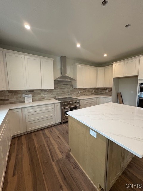 3515 Tall Tree Ln, Lysander, NY 13027 - kitchen with white cabinets, high end stainless steel range oven, backsplash, wall chimney range hood, and light stone counters