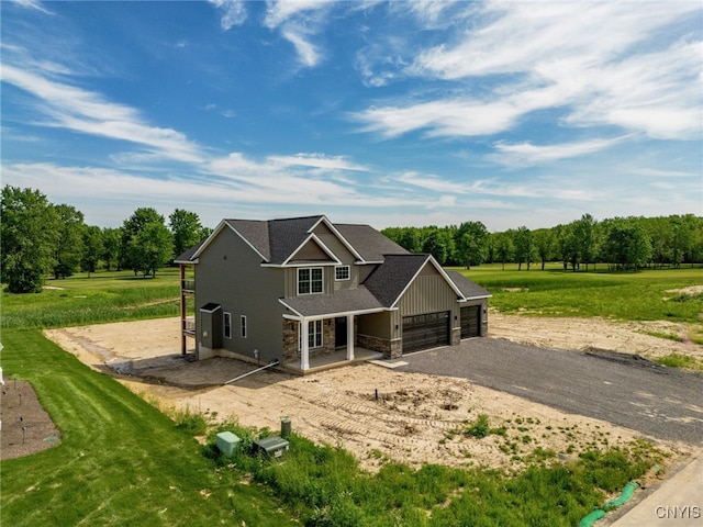 3515 Tall Tree Ln, Lysander, NY 13027 - view of front facade featuring an attached garage, stone siding, dirt driveway, and view of scattered trees