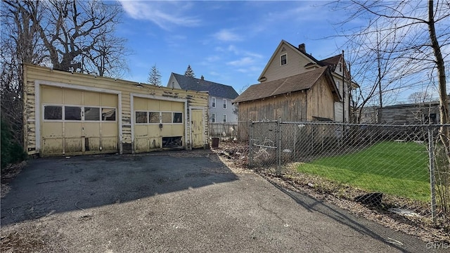 exterior space with a garage, a lawn, an outdoor structure, and fence