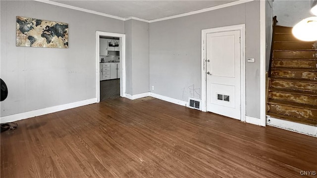 spare room with stairway, wood finished floors, visible vents, and ornamental molding