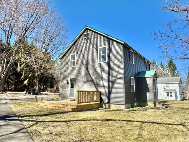 back of house with a lawn, entry steps, and a wooden deck