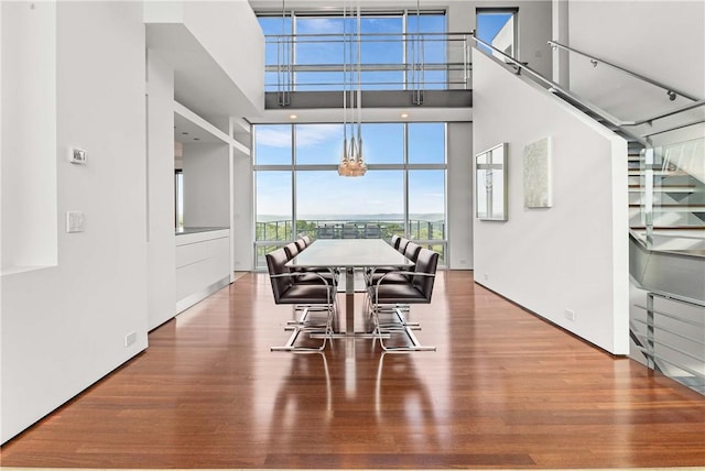 10289-10288 Whispering Wind Trl, Corning, NY 14830 - dining room featuring wood finished floors, a wall of windows, a towering ceiling, and a chandelier